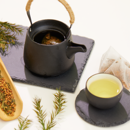 Théière noire, tasse de thé vert et sachets de Genmaicha, avec un mélange de thé et de riz grillé